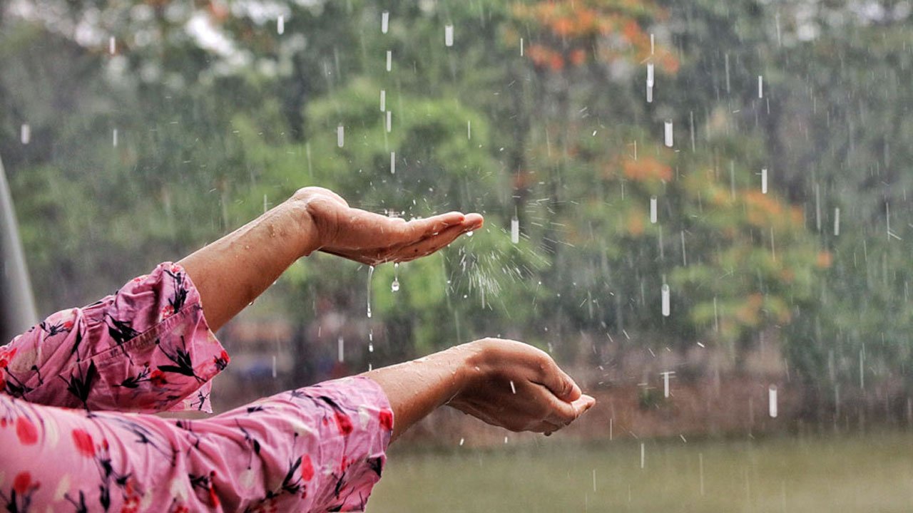 A young woman reached out to touch the rain, even though she had taken shelter in a tent for fear of getting wet.