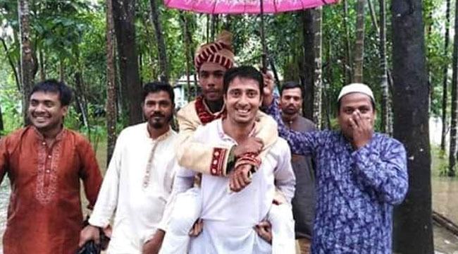 বন্যার মধ্যে কন্যা আনতে ঘাড়ে চাপলেন বর (ছবি ভাইরাল)