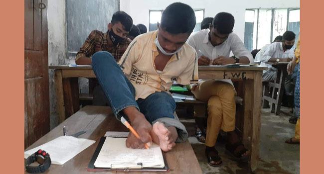 পা দিয়ে লিখে এসএসসি পরীক্ষা দিচ্ছেন মানিক