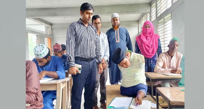 নাটোরের পা দিয়ে লিখে দাখিল পরীক্ষা দিচ্ছে রাসেল