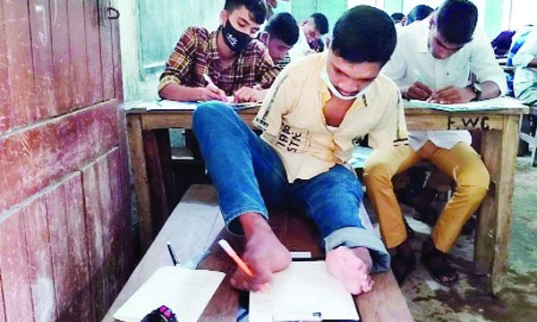 পা দিয়ে লিখেই এসএসসি পরীক্ষা দিচ্ছে ফুলবাড়ীর মানিক