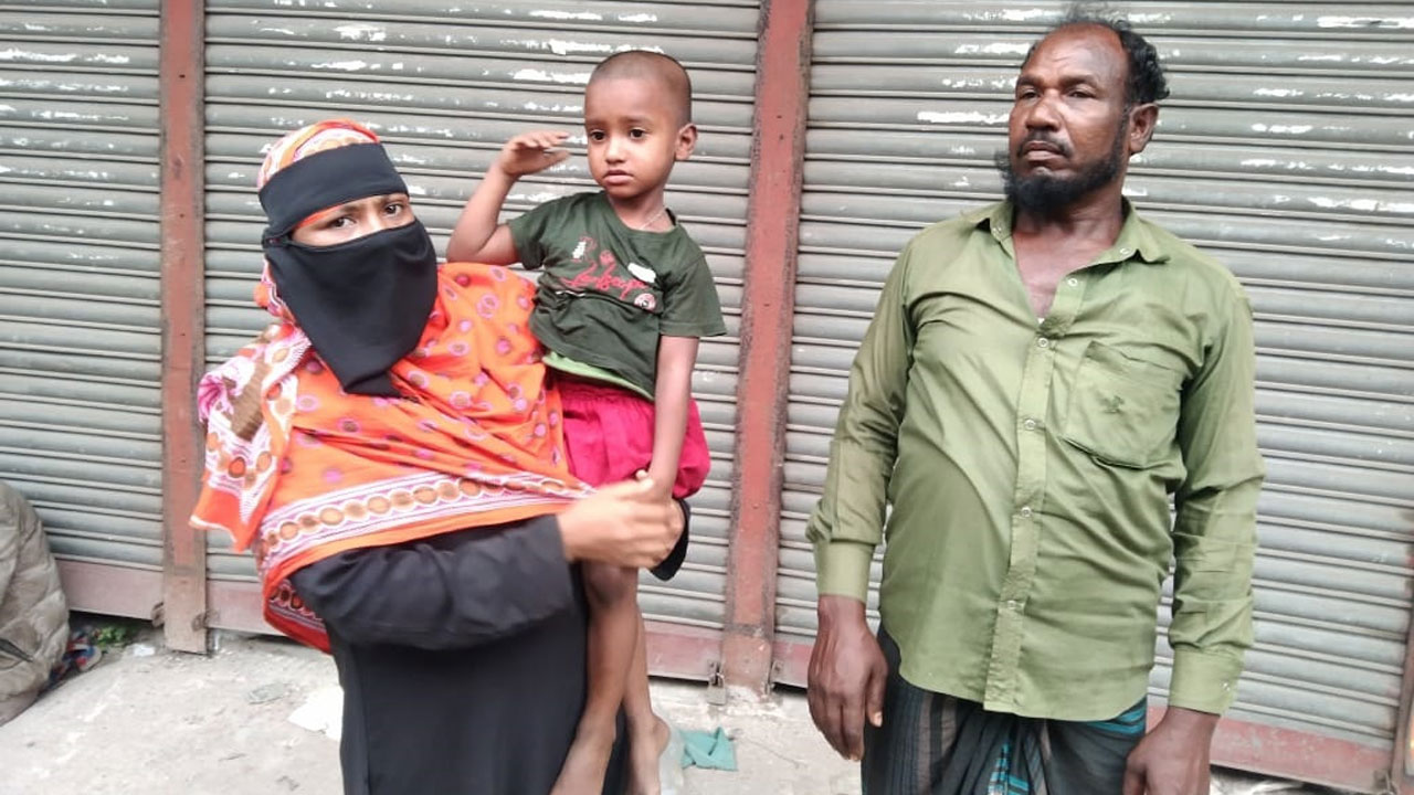 শিশু মো: আল আমিনকে কোলে নিয়ে দাঁড়িয়ে আছেন তার মা, পাশে তার বাবা মো: আজাদ