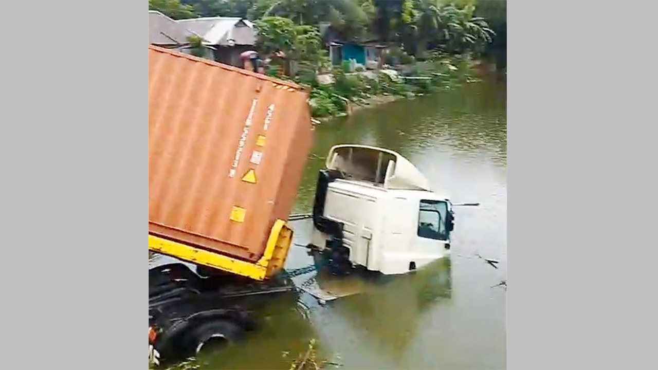 পুকুরে পড়া অবস্থায় লরিটি