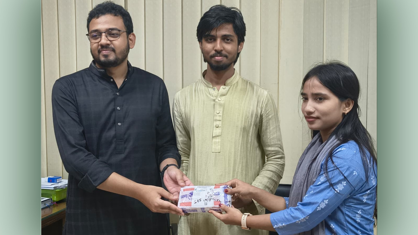 হারানো মোবাইল ফোন শিক্ষার্থীর হাতে তুলে দিচ্ছেন মহিউদ্দিন খান ও মুসাদ্দিক আলী ইবনে মোহাম্মদ