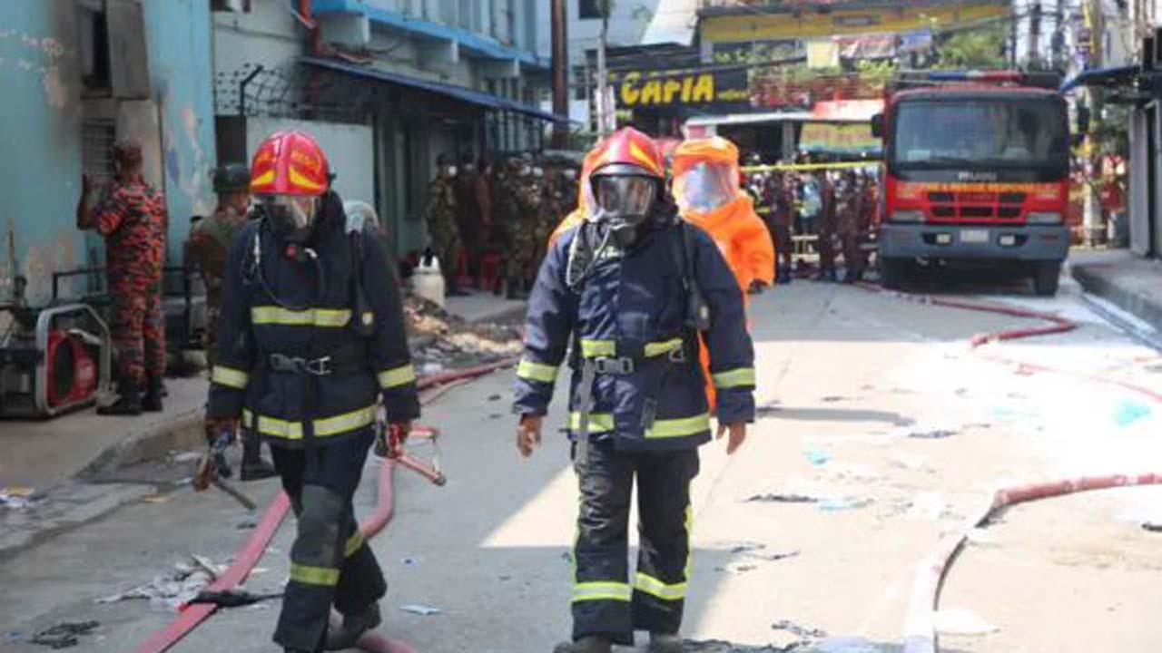 গ্যাস মাস্ক ও নীলচে কালো পোশাক পরা ফায়ার সার্ভিসের দুই কর্মী