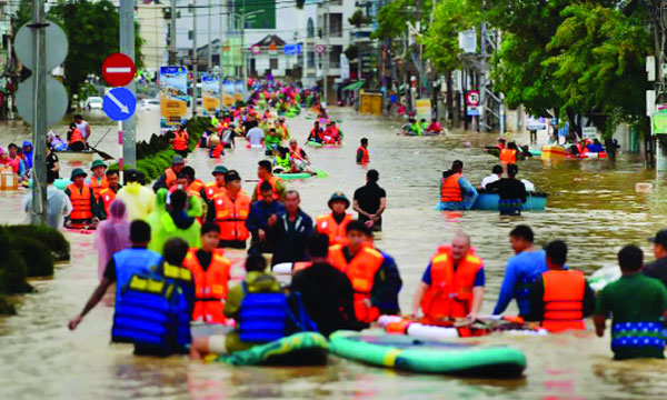 ভিয়েতনামের উপকূলীয় প্রদেশ খান হোয়ার নাহা ট্রাং-এ বন্যার পানি ভেঙে নিরাপদ আশ্রয়ে যাচ্ছেন স্থানীয়রা : ইন্টারনেট