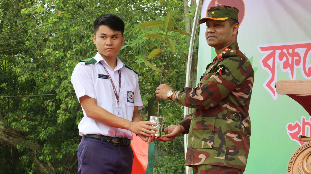শিক্ষার্থীর হাতে গাছের চারা তুলে দিচ্ছেন ব্রিগেডিয়ার জেনারেল কে এম ওবায়দুল হক