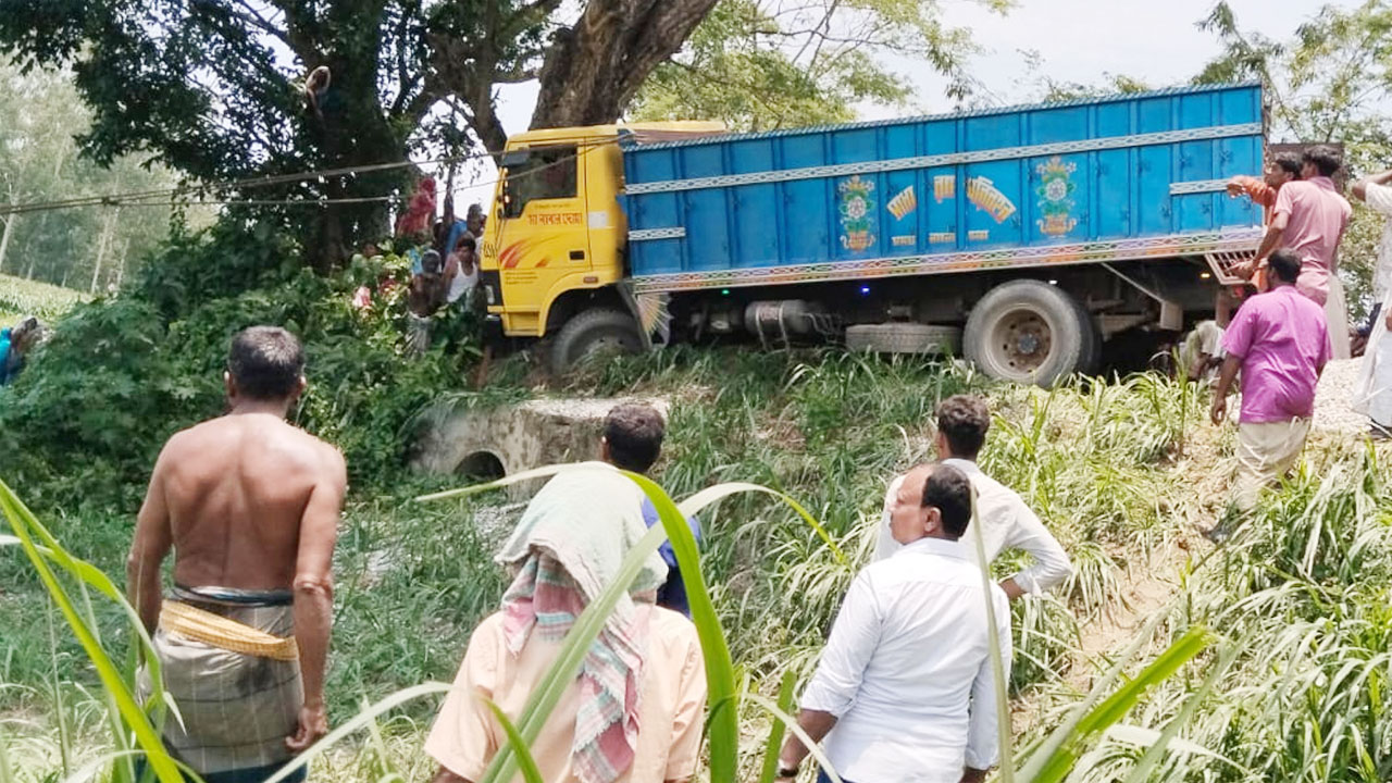 ঘটনাস্থলে দুর্ঘটনাকবলিত ট্রাক, পাশে স্থানীয় উৎসুক জনতার ভিড়