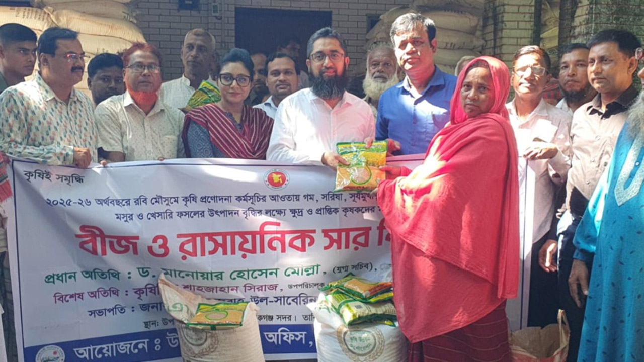 একজন কৃষাণীর হাতে সার ও বীজ তুলে দেয়া হচ্ছে