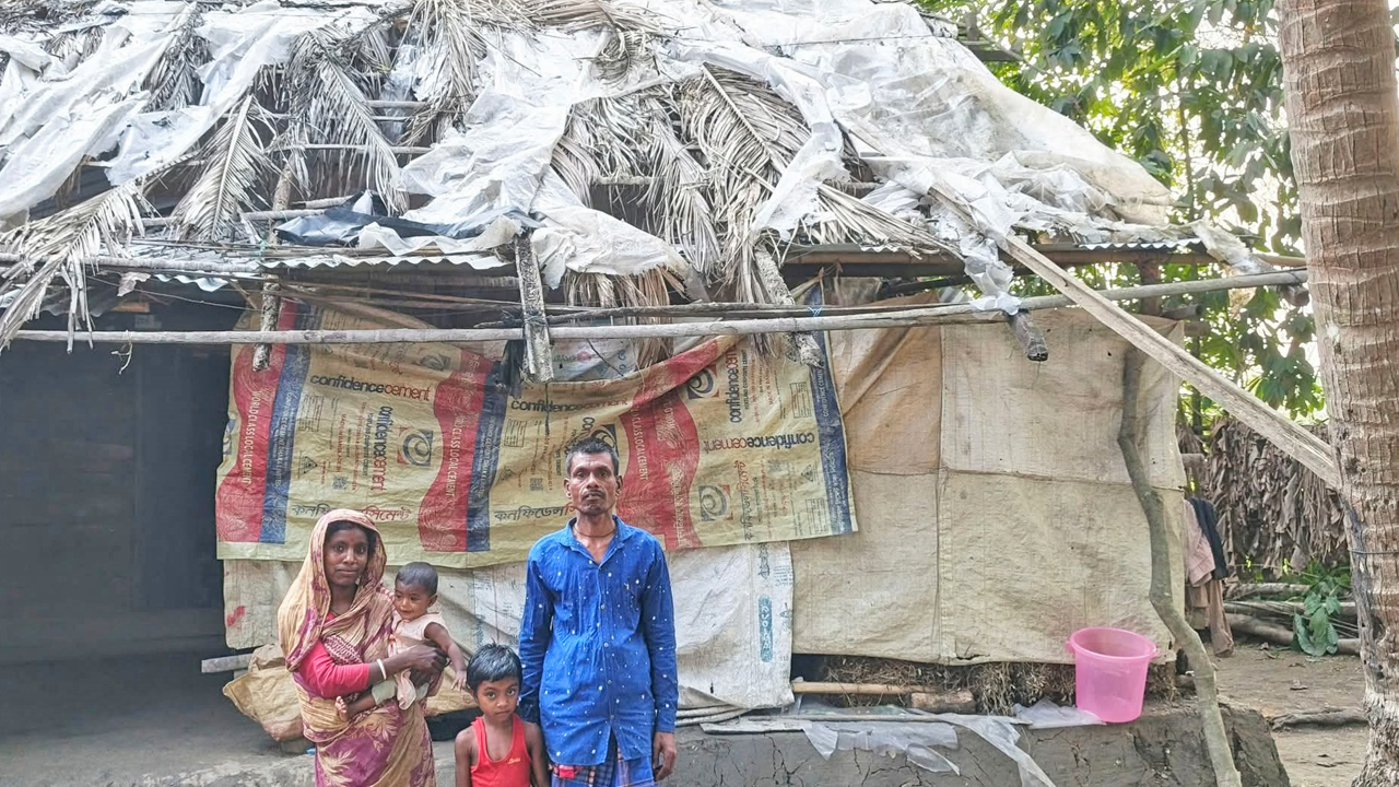 পলিথিনের ছাউনি ঘরের সামনে নির্মল ও তার পরিবার