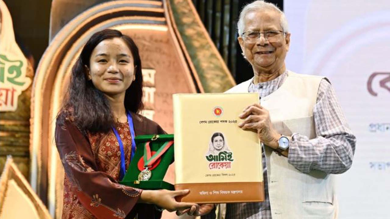 প্রধান উপদেষ্টা অধ্যাপক ড. মুহাম্মদ ইউনূসের হাত থেকে পদক নিচ্ছেন তারকা ফুটবলার ঋতুপর্ণা চাকমা