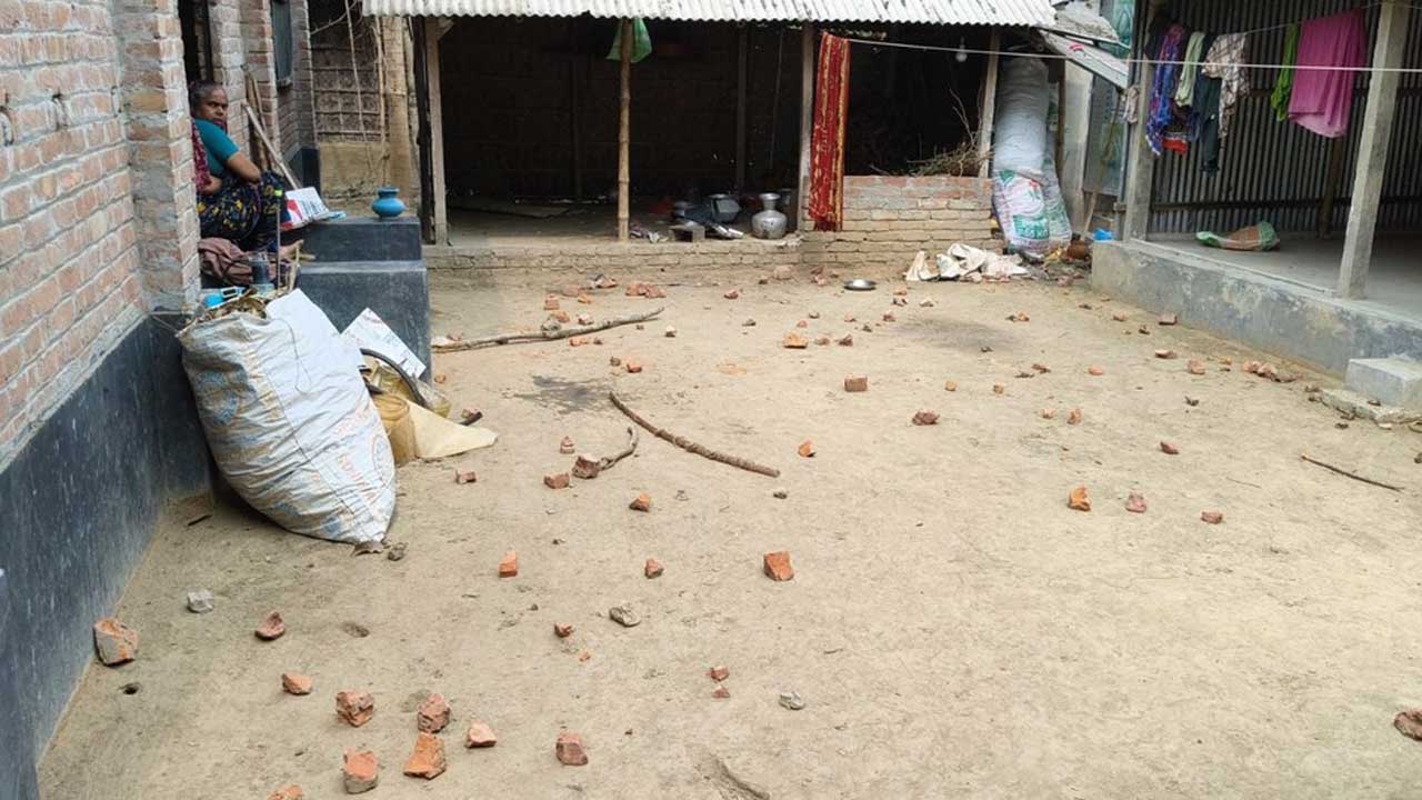 শৈলকুপার জালিয়াপাড়া গ্রামে সংঘর্ষের পর একটি বাড়ির উঠানে ছড়িয়ে থাকা ইট-পাটকেলে