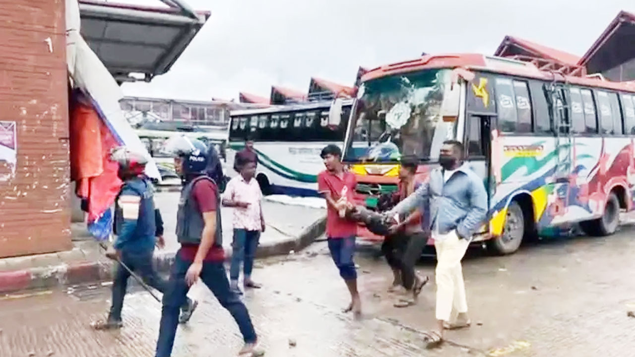 সংঘর্ষে আহত এক শ্রমিককে উদ্ধার করছেন সহকর্মীরা