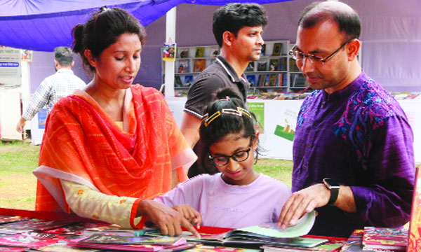 অমর একুশে বই মেলায় শিশু প্রহরে বই দেখছে শিশু  : নয়া দিগন্ত