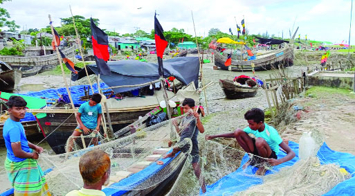নোয়াখালীর উপকূলে জাল মেরামত করে সময় পার করছেন জেলেরা : নয়া দিগন্ত