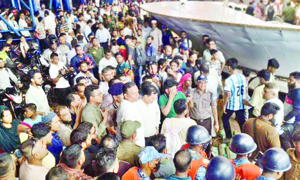 বরিশাল লঞ্চ টার্মিনালে দাঁড়িয়ে আছেন যাত্রীরা : নয়া দিগন্ত