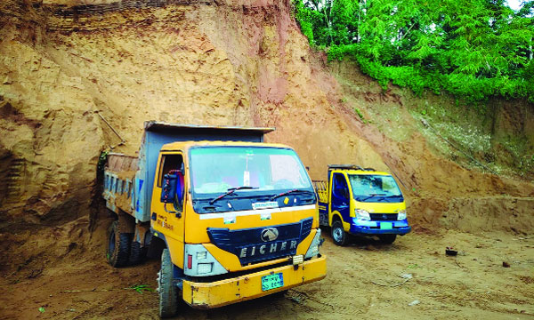 জৈন্তাপুরের একটি টিলা কেটে ট্রাকে মাটি ভর্তি করা হচ্ছে :  নয়া দিগন্ত
