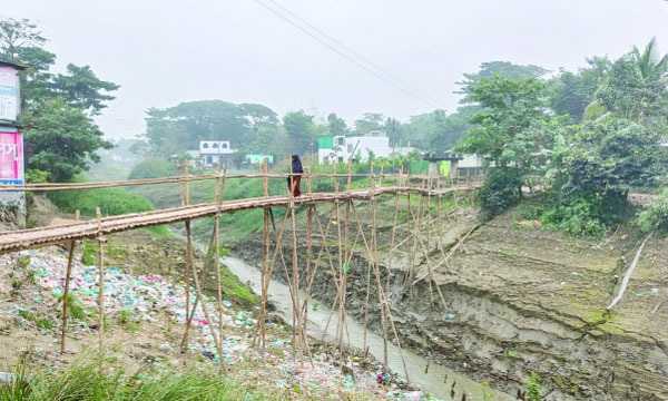 সিলেটের কুশিঘাট বাজার থেকে নয়া বস্তিতে যাতায়াতের জন্য এখনো কোনো পাকা সেতু নির্মাণ করা হয়নি। ফলে এলাকাবাসীকে প্রতিদিন জীবনের ঝুঁকি নিয়ে অস্থায়ী বাঁশের সেতু পার হতে হয়। এই সেতু দিয়ে স্কুলশিক্ষার্থী, বৃদ্ধ, নারীসহ নানা বয়সের মানুষ চলাচল করে। বর্ষা মৌসুমে সেতুটি আরো বিপজ্জনক হয়ে ওঠে। দীর্ঘদিন ধরে পাকা সেতুর দাবি জানালেও সংশ্লিষ্ট কর্তৃপক্ষের কার্যকর উদ্যোগ চোখে পড়ছে না। : ছবিটি তুলেছেন জয়নাল আবেদীন আজাদ